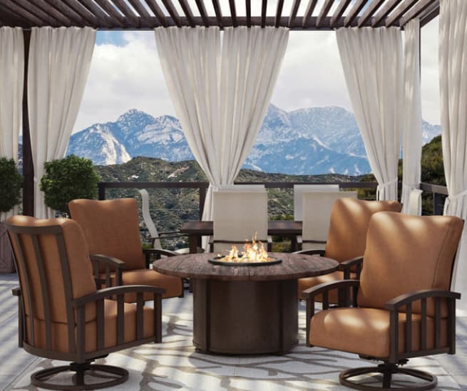 Enclosed gazebo with drapes with deep seating around outdoor gas fire table