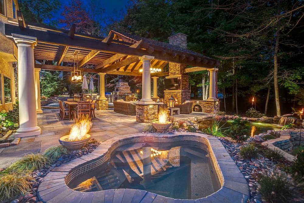 luxury outdoor living space with hot tub and outdoor kitchen