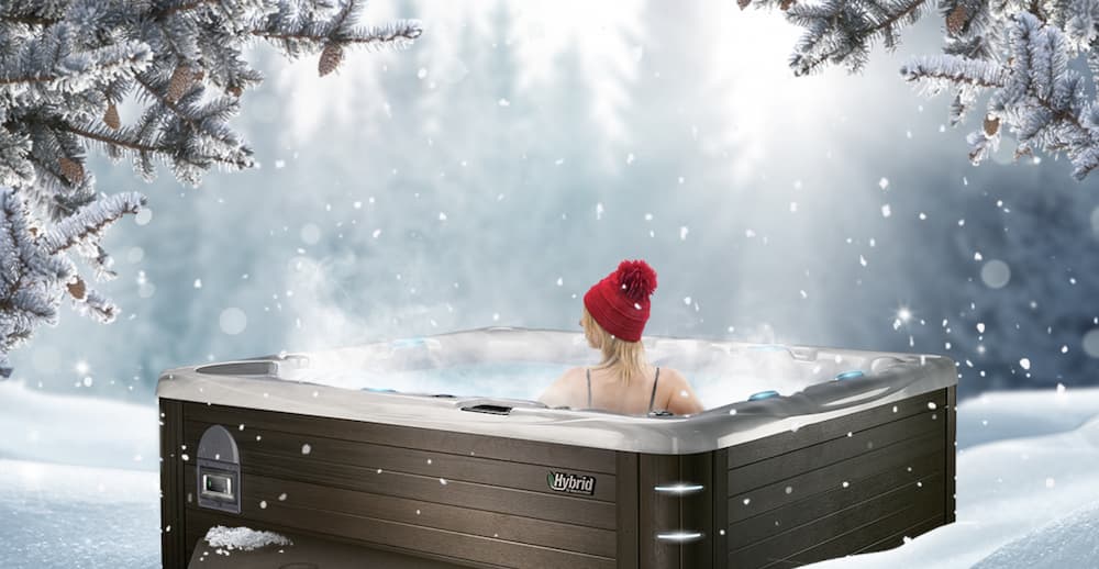 woman in hot tub in the winter while snowing at dusk